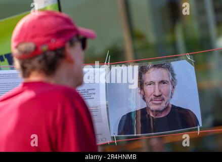 28. Mai 2023, Hessen, Frankfurt/Main: Ein Mann betrachtet das Porträt des Musikers Roger Waters bei einer Gegenveranstaltung, bei der versucht wird, die Position des Sängers am Rande einer Demonstration unter dem Motto "Frankfurt vereint gegen den Antisemitismus" darzustellen. Waters wird eine antisemitische Haltung vorgeworfen. Foto: Andreas Arnold/dpa Stockfoto