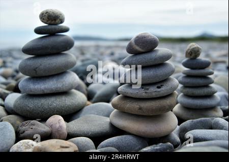 Drei Zen-Türme an einem steinigen Strand. Türme aus Kieselsteinen. Stockfoto