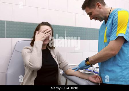 Der Arzt nimmt dem Patienten in der Klinik Blut ab Stockfoto