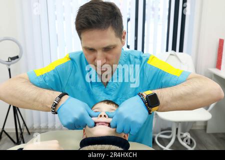 Osteopath behandelt die Atmungsorgane des Schuljungen in der Klinik Stockfoto
