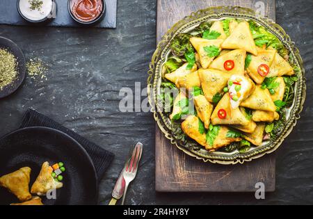 Köstliche vegetarische Samosa mit Tomaten- und Joghurt-Sauce. Draufsicht mit Nahaufnahme. Stockfoto