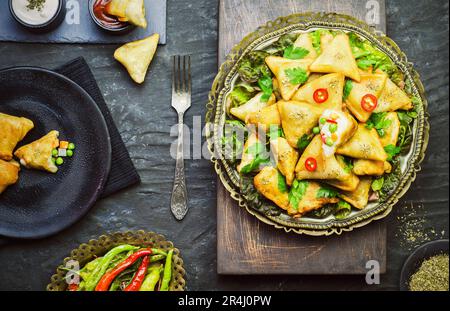 Köstliche vegetarische Samosa mit Tomaten- und Joghurt-Sauce. Draufsicht mit Nahaufnahme. Stockfoto