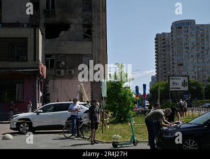 Kiew, Ukraine. 28. Mai 2023. Personen auf der Straße in der Nähe des beschädigten Gebäudes aufgrund eines Angriffs der iranischen Shahed-Gruppe griffen die Drohne der russischen Armee in Kiew an. Die russische Armee griff die Ukraine mit Shahed-Angriffsdrohnen an. Das ukrainische Militär zerstörte 52 von 54 russischen Drohnen. In der Hauptstadt der Ukraine wurden mehr als 40 Drohnen abgeschossen. Kredit: SOPA Images Limited/Alamy Live News Stockfoto