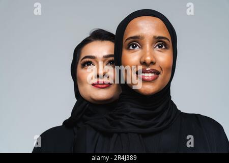 Wunderschöne arabische Frauen aus dem Nahen Osten mit traditionellem Abaya-Kleid im Studio - arabisch-muslimisches Frauenporträt in Dubai, Vereinigte Arabische Emirate Stockfoto