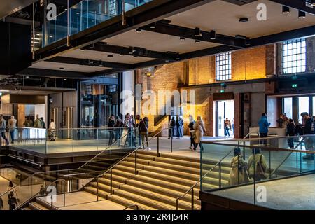 Die Leute am Südeingang des Atriums am neu renovierten Battersea Power Station sind heute ein wichtiges Einkaufs- und Freizeitziel, London SW11 Stockfoto