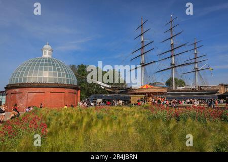 London, Großbritannien. 28. Mai 2023. Der restaurierte Cutty Sark Teeclipper scheint in einem Meer aus weichem, grünem Gras in den Cutty Sark Gardens zu schweben. Die Leute entspannen sich in der wunderschönen Sonntagssonne von Bank Holiday in Greenwich, Südost-London. Kredit: Imageplotter/Alamy Live News Stockfoto