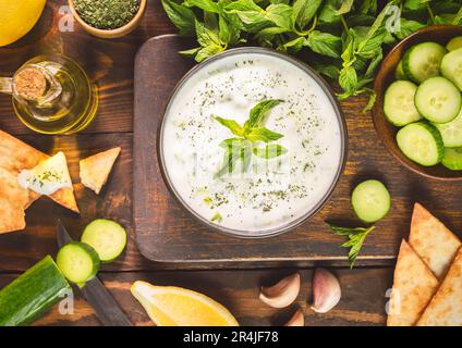 Arabische Küche; traditioneller Joghurt-Gurkensalat. Es besteht aus cremigem Joghurt, geriebener Gurke, frischer Minze und Knoblauch. Draufsicht mit Nahaufnahme. Stockfoto