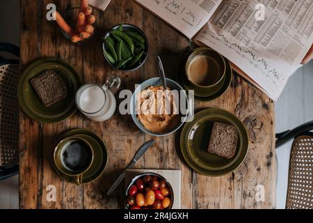Direkt über dem Frühstück auf einem hölzernen Esstisch zu Hause Stockfoto
