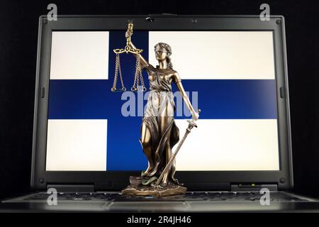 Symbol für Recht und Gerechtigkeit mit finnischer Flagge auf dem Laptop. Studioaufnahme. Stockfoto