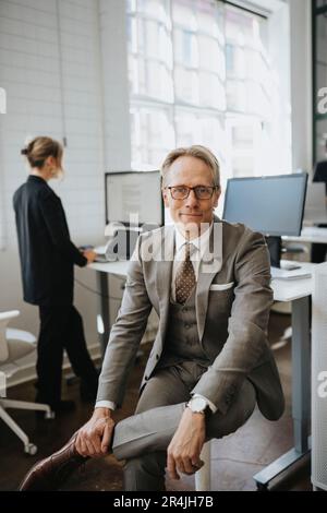 Porträt eines lächelnden Geschäftsmannes mit Brille im Büro Stockfoto