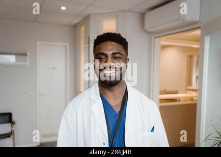 Porträt eines lächelnden jungen Arztes im Krankenhaus mit Laborkittel Stockfoto