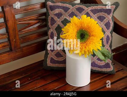 Flauschige gelbe Sonnenblume in einer kleinen Milchdose. Stockfoto