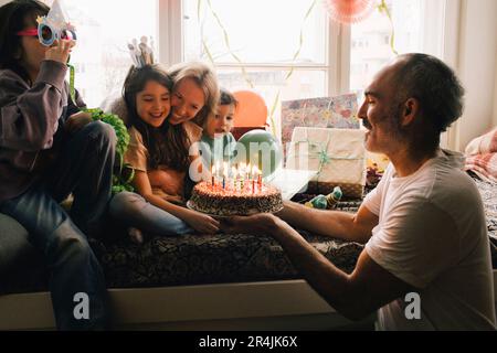 Glückliche Familie feiert Geburtstag mit Kuchen zu Hause Stockfoto