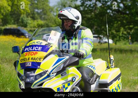 RideLondon Classique 2023 Stage 2 führt durch das Dorf Layer-de-la-Haye in der Nähe von Colchester in Essex. Polizist auf Motorrad unterwegs Stockfoto