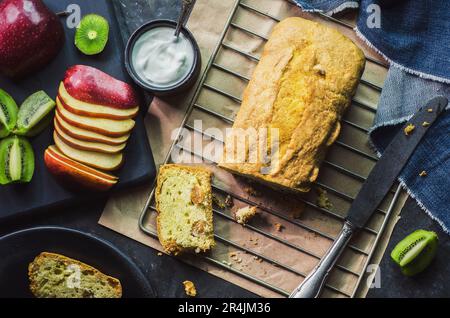 Köstlicher traditioneller Obstkuchen mit Rosinen. Serviert mit frischem Obst und Clotted Cream. Draufsicht mit Nahaufnahme. Stockfoto