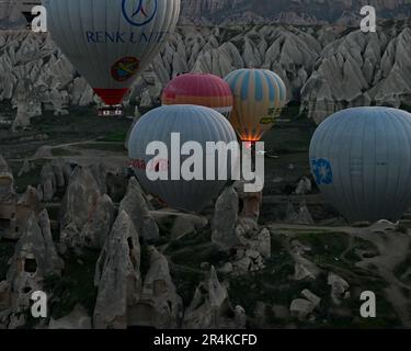 Heißluftballons, die zu Beginn eines Sonnenaufgangs abheben, in der Nähe des Zelve Open Air Museums, Kappadokien, Türkei Stockfoto