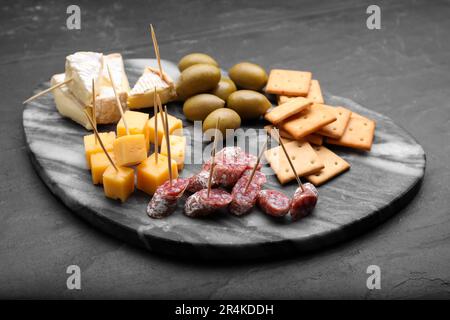 Zahnstocher-Vorspeisen. Würstchen, Käse und Cracker auf dem schwarzen Tisch Stockfoto