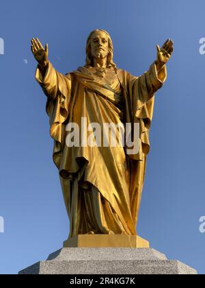 Goldene Statue Jesu gegen den Blauen Himmel Stockfoto