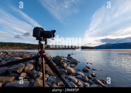 Sonnenuntergang auf einem atemberaubenden, ruhigen See in Kanada mit Kamera auf Stativ und Fotoaufnahmen. Stockfoto