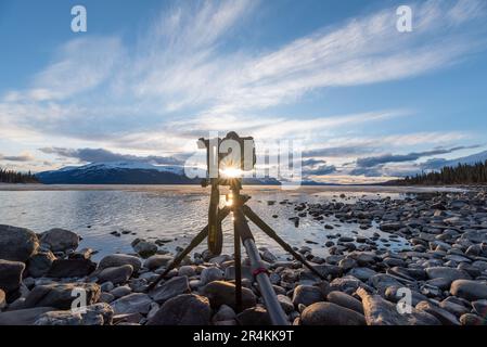 Sonnenuntergang auf einem atemberaubenden, ruhigen See in Kanada mit Kamera auf Stativ und Fotoaufnahmen. Stockfoto