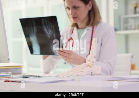 Die Arbeitskleidung des Arztes untersucht Knochenverletzungen auf dem Röntgenbild Stockfoto