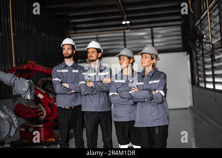 Selbstbewusstes Roboterteam, darunter Frauen in einem nicht typischerweise von Männern dominierten Feld, kreuzt die Arme und repräsentiert das Engagement des Unternehmens für Vielfalt und Inklusion Stockfoto