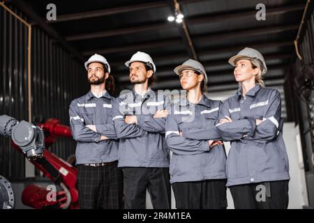 Selbstbewusstes Roboterteam, darunter Frauen in einem nicht typischerweise von Männern dominierten Feld, kreuzt die Arme und repräsentiert das Engagement des Unternehmens für Vielfalt und Inklusion Stockfoto