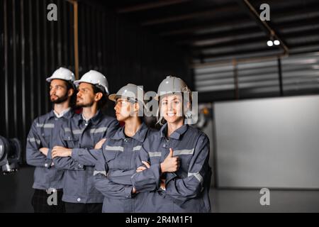 Selbstbewusstes Roboterteam, darunter Frauen in einem nicht typischerweise von Männern dominierten Feld, kreuzt die Arme und repräsentiert das Engagement des Unternehmens für Vielfalt und Inklusion Stockfoto