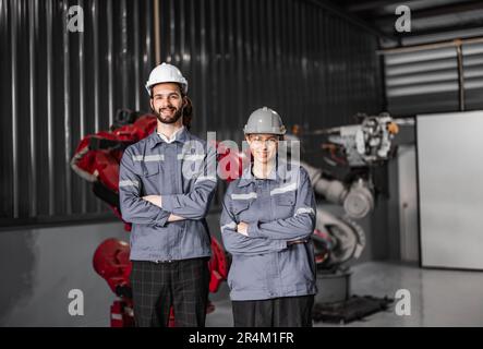 Selbstbewusstes Roboterteam, darunter Frauen in einem nicht typischerweise von Männern dominierten Feld, kreuzt die Arme und repräsentiert das Engagement des Unternehmens für Vielfalt und Inklusion Stockfoto