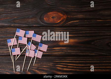 Kleine Papierflaggen der USA auf Holztisch, flach liegend. Platz für Text Stockfoto