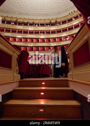 Im Inneren der Scala Opera House in Mailand, Lombardei, Italien, bewundern die Menschen diesen berühmten Ort mit seinen eleganten Sitzgelegenheiten und privaten Boxen, Stockfoto