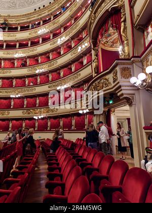 Im Inneren der Scala Opera House in Mailand, Lombardei, Italien, bewundern die Menschen diesen berühmten Ort mit seinen eleganten Sitzgelegenheiten und privaten Boxen, Stockfoto