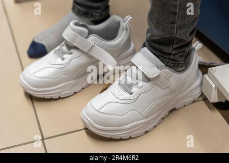 Neue modische Sneaker in einem Schuhgeschäft. Neue Schuhe kaufen Stockfoto