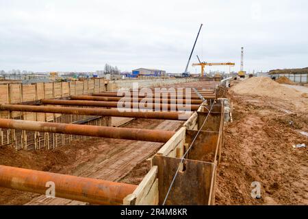 Ein riesiger Gräben-Tunnel mit Verstärkungsstrukturen aus dicken Eisenrohren und Bauten auf der Baustelle des unterirdischen Me Stockfoto