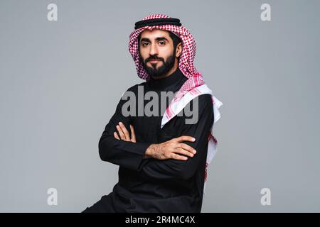Attraktiver arabischer Saudi-arabischer Mann aus dem Nahen Osten mit traditioneller saudi-Kleidung im Studio - arabisch-muslimischer erwachsener Geschäftsmann mit tollem Porträt Stockfoto