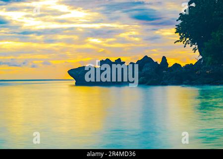 Strandlandschaft mit Felsformationen während des Sonnenaufgangs am Sumurtiga Beach, Sabang, Aceh, Indonesien. Stockfoto