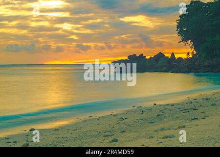 Strandlandschaft mit Felsformationen während des Sonnenaufgangs am Sumurtiga Beach, Sabang, Aceh, Indonesien. Stockfoto