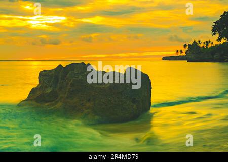 Strandlandschaft mit Felsformationen während des Sonnenaufgangs am Sumurtiga Beach, Sabang, Aceh, Indonesien. Stockfoto