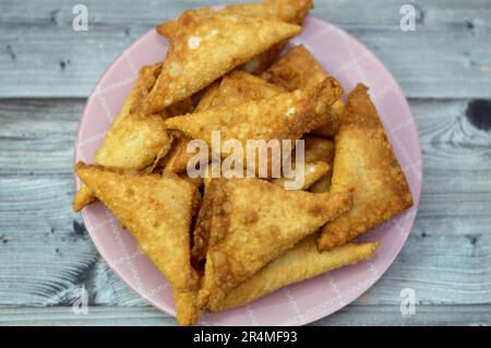 Ein Samosa Singara, ein frittiertes südasiatisches Gebäck mit einer herzhaften Füllung, einschließlich Zutaten wie Gewürzkartoffeln, Zwiebeln, Erbsen, Fleisch oder Fisch, Sambousek Stockfoto