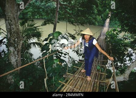 Frau überquert Hängebrücke über den Loboc River Stockfoto