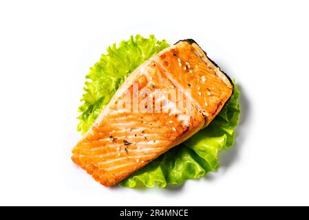 Gegrilltes Lachssteak isoliert auf weißem Hintergrund. Gerösteter Lachs auf Salatblatt - gesunde Keto-Lebensmittelzutat. Stockfoto