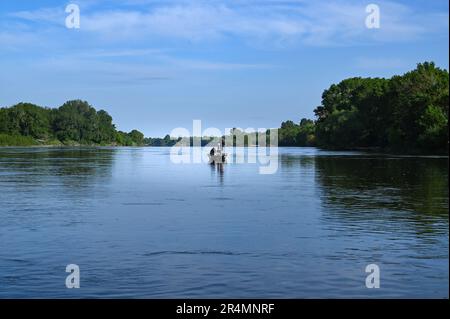 Männer, die von einem Boot aus in der Mitte der Loire bei Saumur, Frankreich, fischen Stockfoto