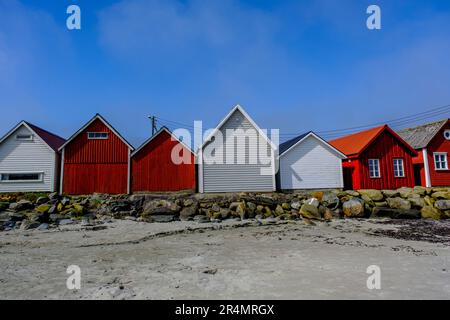 Olberg; Olbergstranden; Raege; Norwegen; Mai 20 2023; Reihe oder Reihe traditioneller Holzhütten am Strand gegenüber Einem Sandstrand und einem klaren frühen Morgen BL Stockfoto