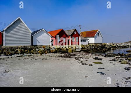 Olberg; Olbergstranden; Raege; Norwegen; Mai 20 2023; Reihe oder Reihe traditioneller Holzhütten am Strand gegenüber Einem Sandstrand und einem klaren frühen Morgen BL Stockfoto