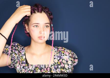 Mädchen mit braunen Haaren und Zöpfen, geflochten mit künstlichem Haargeflecht. Stockfoto