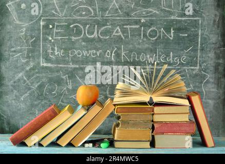 Ein Stapel Bücher mit Schriftzug vor einer Tafel. Lernen, Bildung, Lesen, zurück zur Schule Konzept. Stockfoto