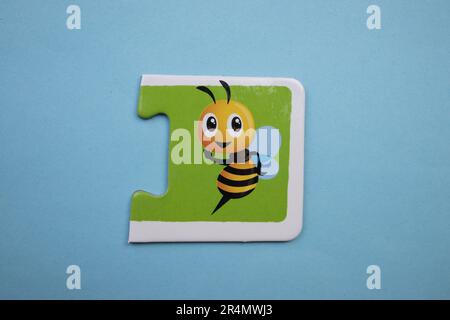 Puzzles auf blauem Hintergrund überlagern. Biene von oben fotografiert. Stockfoto