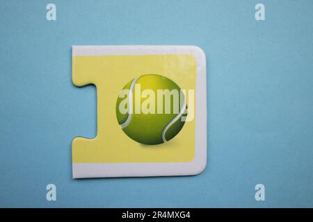 Puzzles auf blauem Hintergrund überlagern. Tennisball von oben fotografiert. Stockfoto