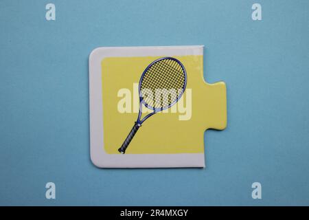 Puzzles auf blauem Hintergrund überlagern. Tennisschläger von oben fotografiert. Stockfoto