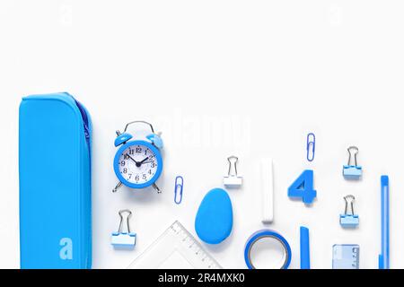 Schulanfang, Berufsbildungskonzept. Sortiment an blauen Vorräten, Buntstiften, Uhr, Stiften auf einem Tisch. Hintergrund des Kopierbereichs, Draufsicht flach Stockfoto
